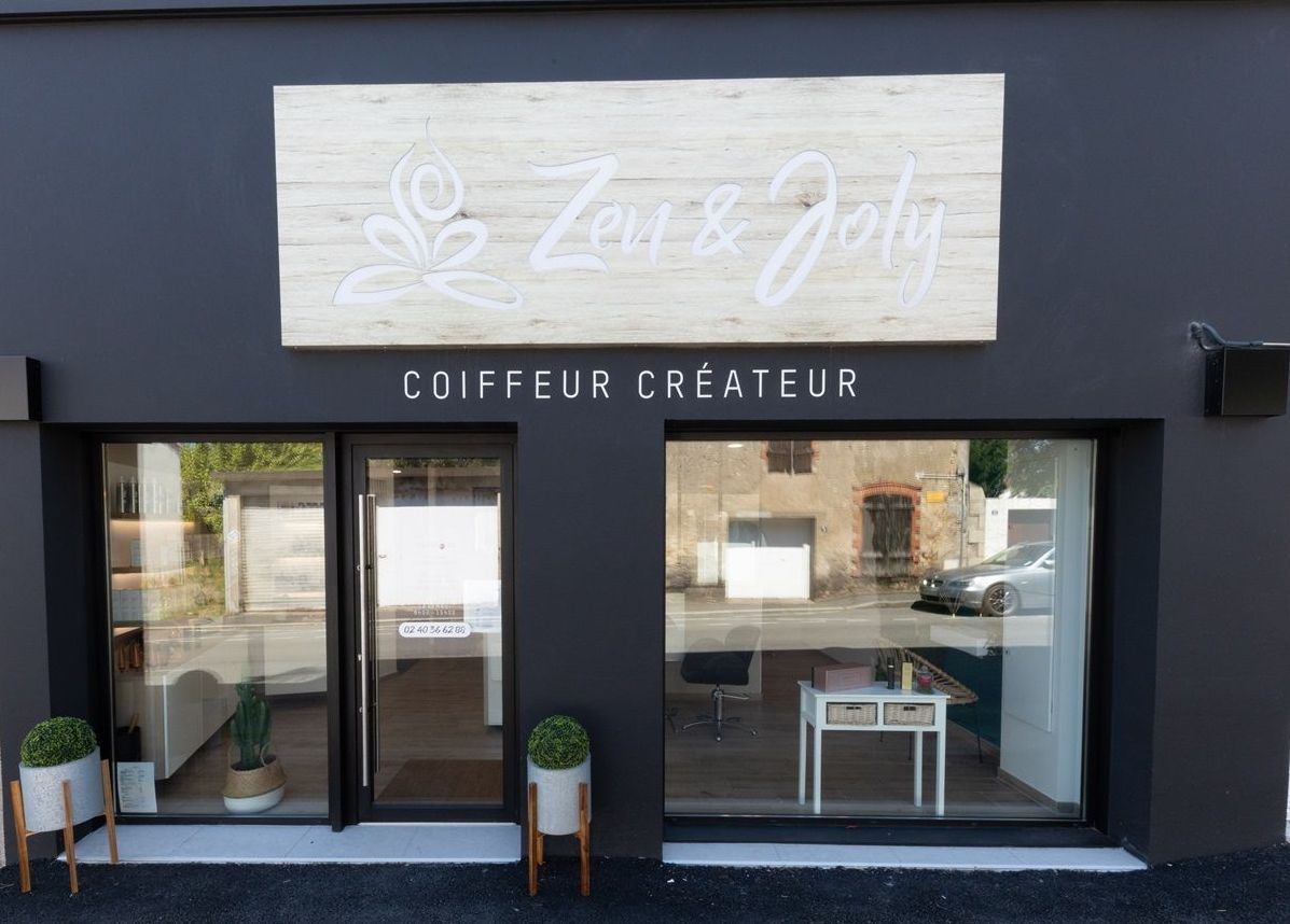 Un bâtiment noir avec un panneau indiquant coiffeur créateur