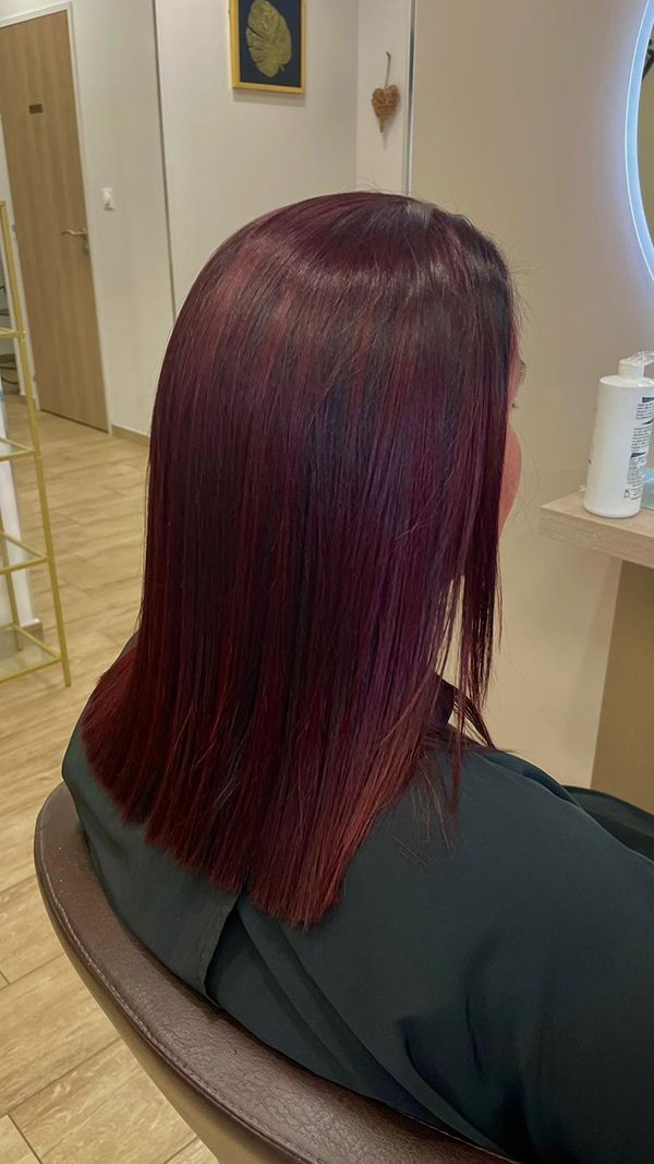 Une femme aux cheveux roux est assise sur une chaise dans un salon.