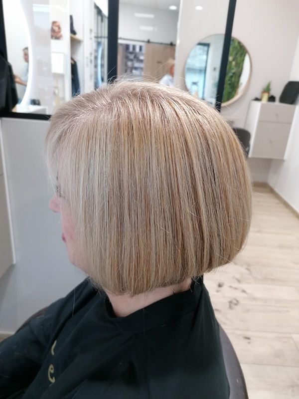 Une femme se fait couper les cheveux dans un salon.