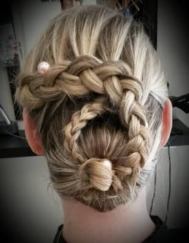 Une femme porte un chignon tressé avec une perle dedans.