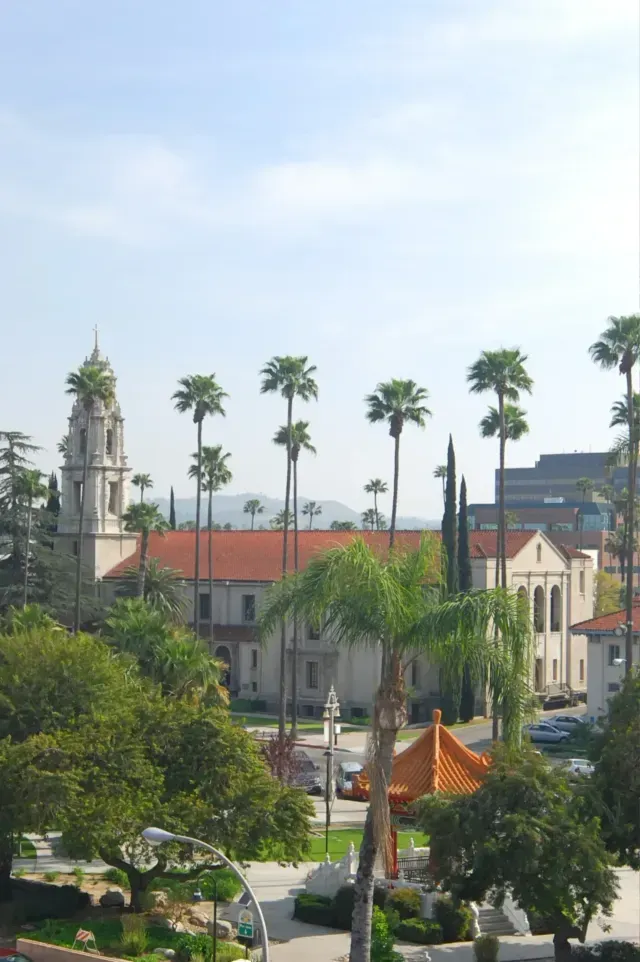Tree Service El Monte Ca - Aerial view of a busy urban intersection with modern apartments, homes, and hills in the background under clear blue skies.