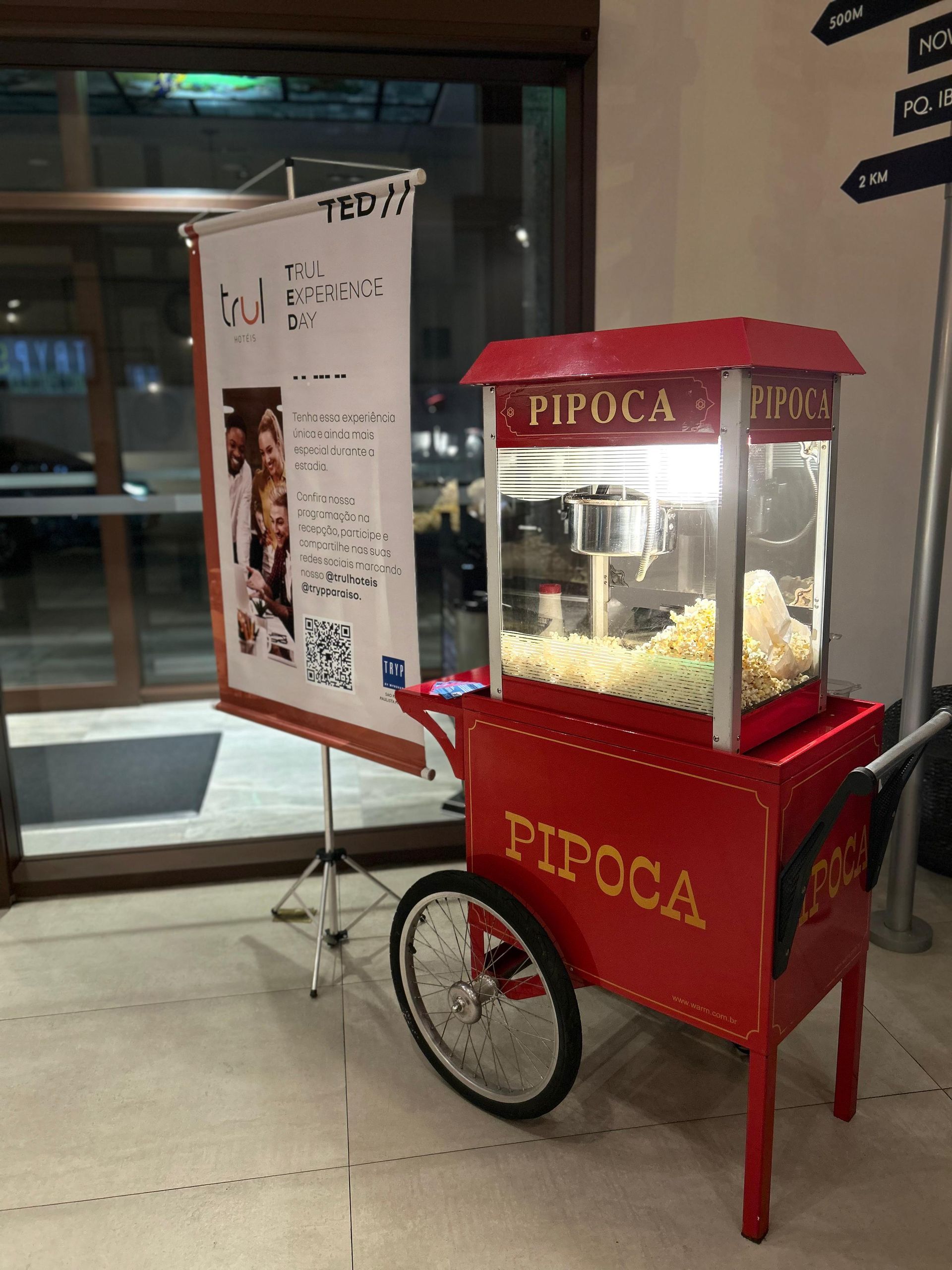 Um carrinho de pipoca vermelho com a palavra