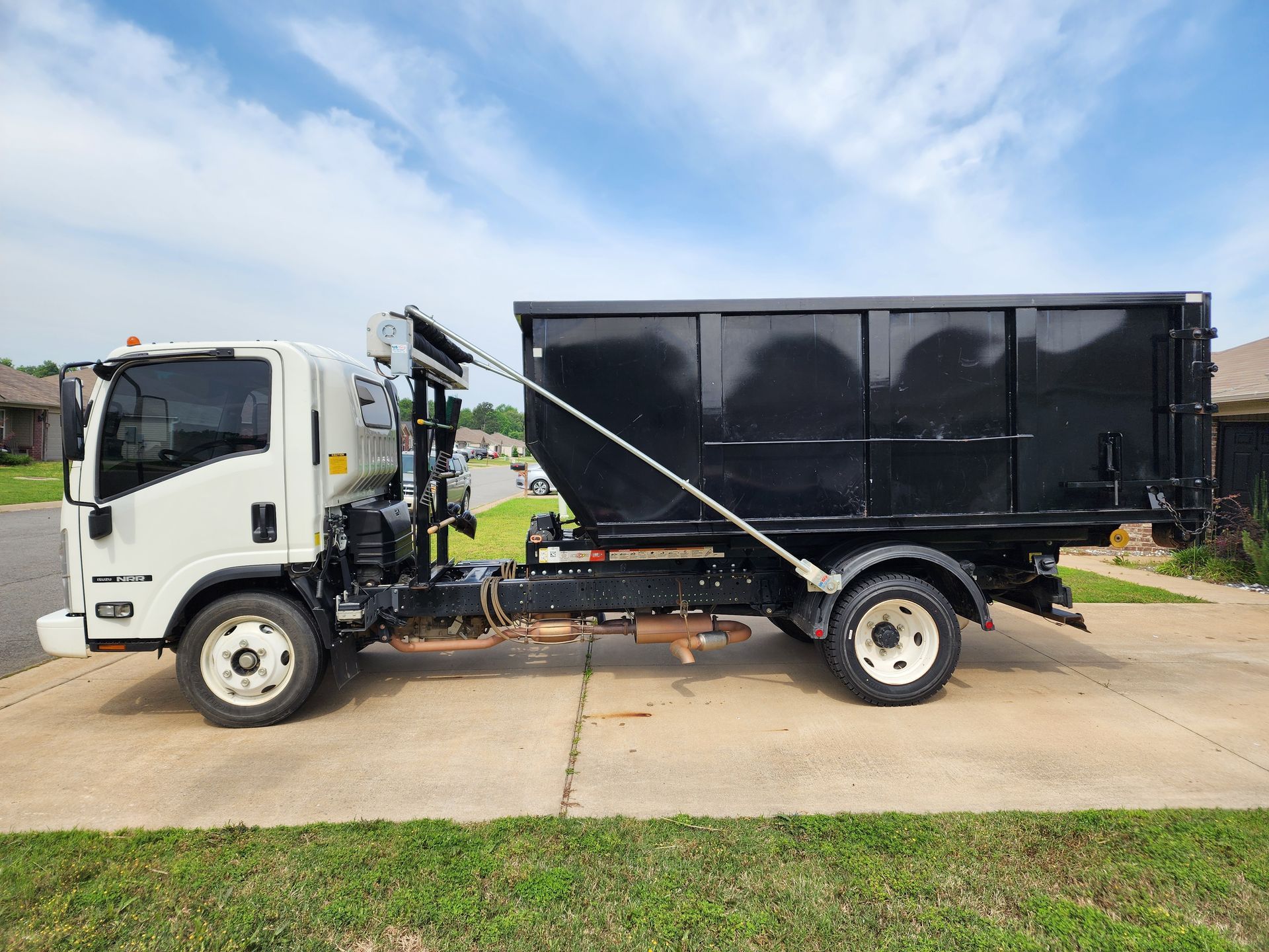 A dump truck is parked in a driveway next to a house.