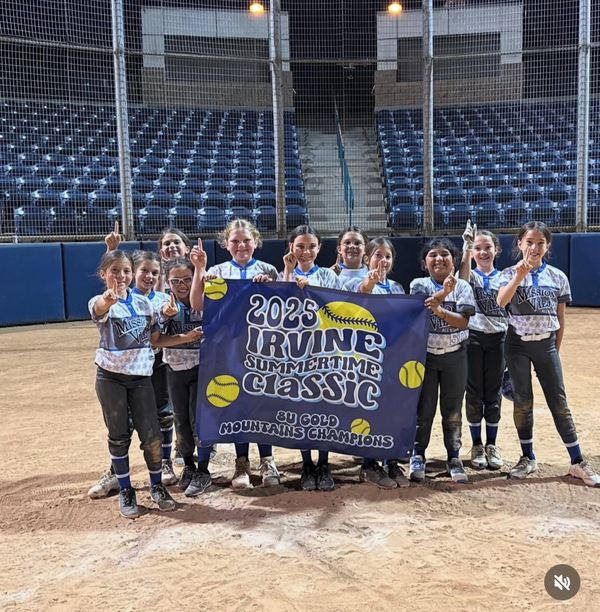 Youth softball team holding a banner, celebrating a tournament win, wearing team uniforms.