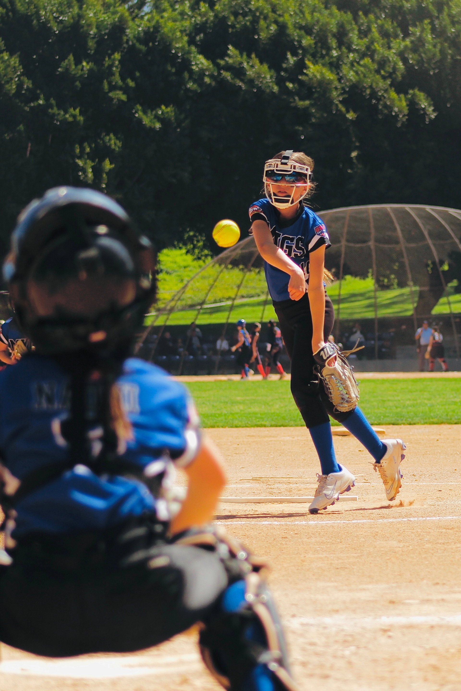 Youth softball team holding a banner, celebrating a tournament win, wearing team uniforms.