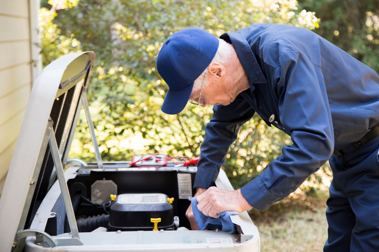 HVAC technician inspecting an outdoor AC condenser for late-season performance issues.