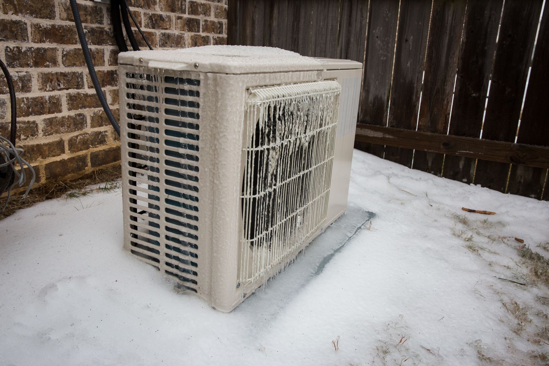 Mini split air conditioning outdoor unit covered in ice from winter storm.