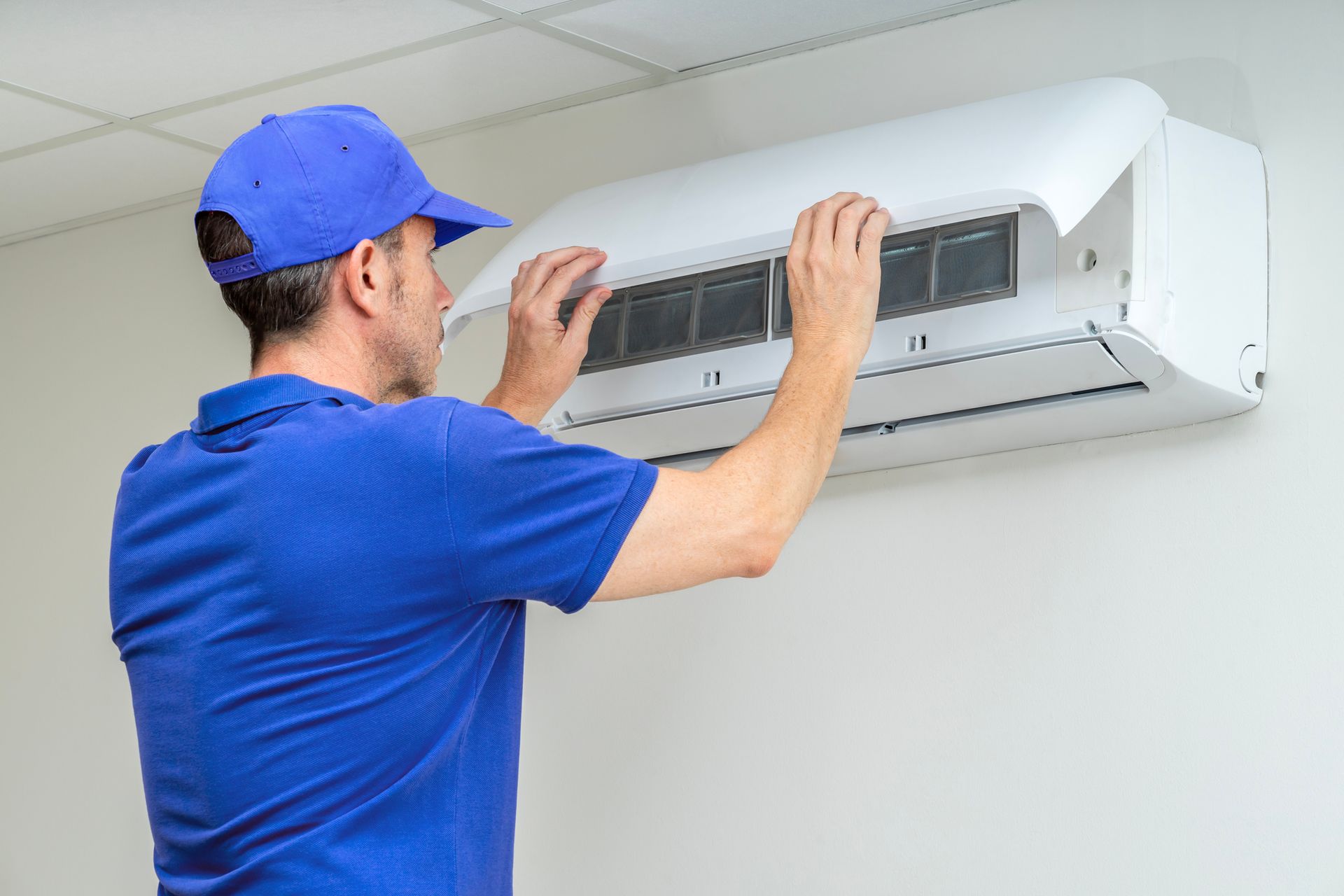Astoria HVAC technician inspecting air conditioner for potential replacement options in Oviedo.