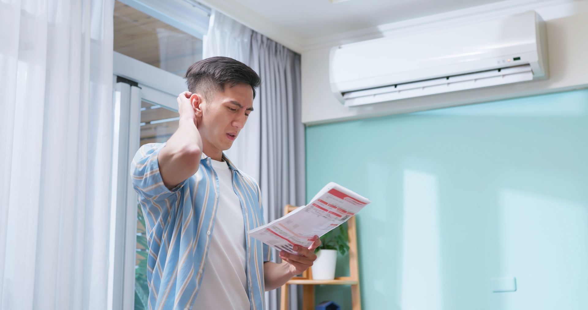 Florida homeowner reviewing high summer electricity bill caused by increased air conditioning.