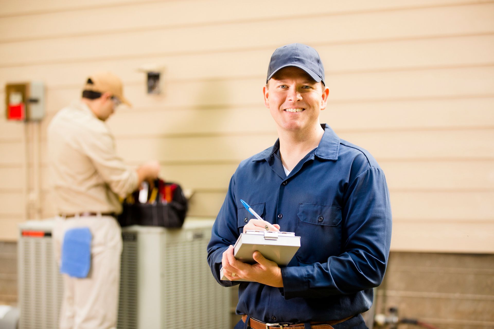 Astoria HVAC technician inspecting air conditioner during spring maintenance in Longwood Florida.