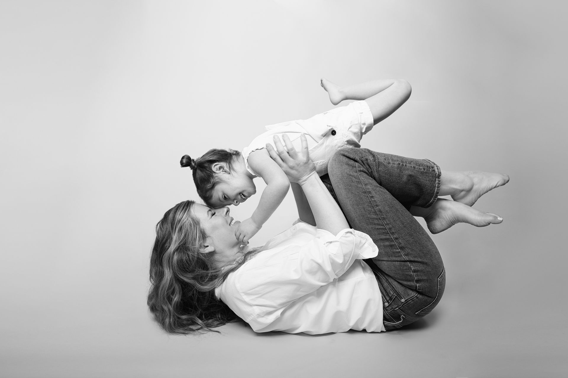 Black and white photo of mom and 3 year old daughter, candid moments in studio