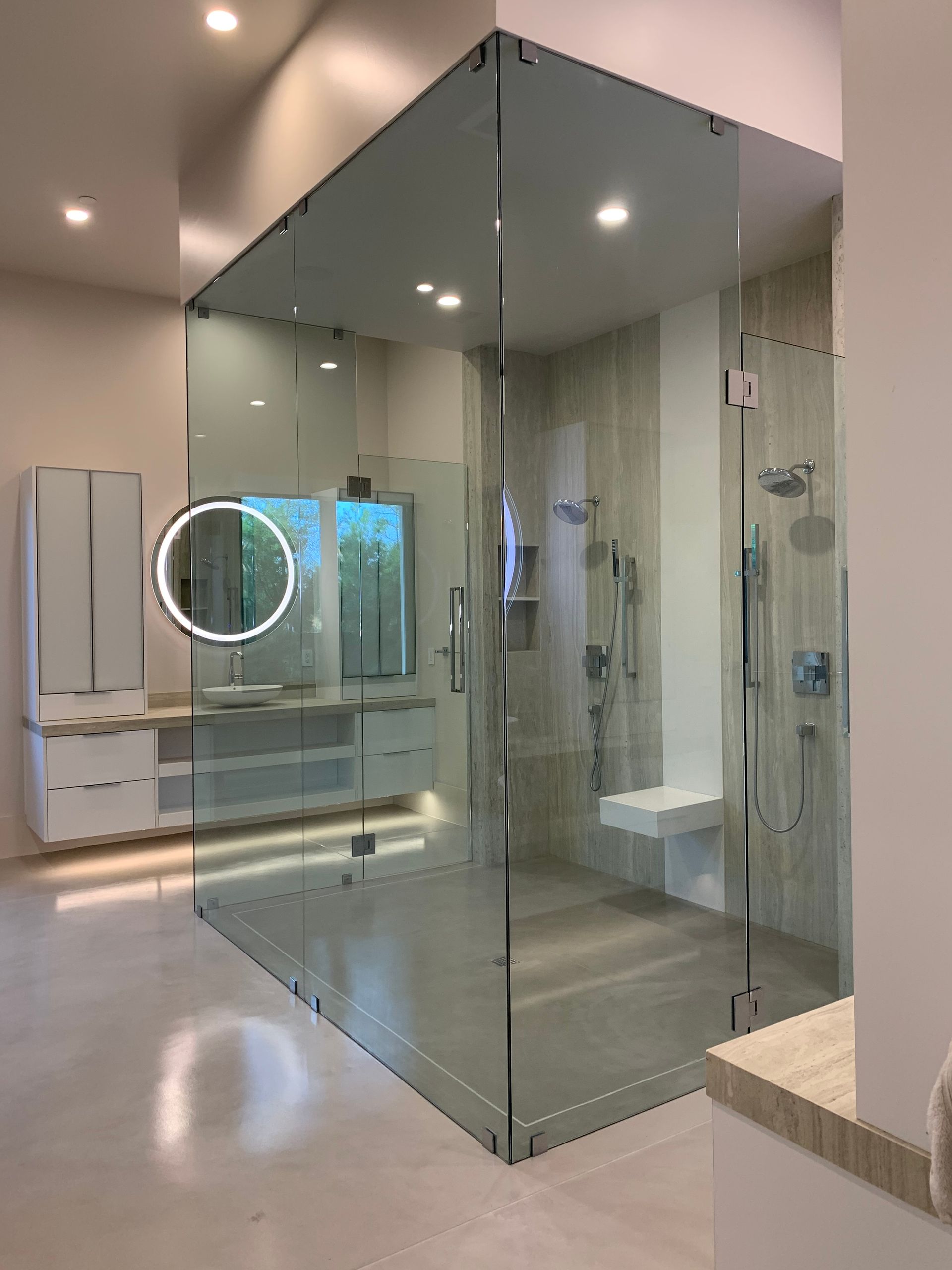 Modern bathroom with a glass-enclosed shower, vanity, and illuminated mirror