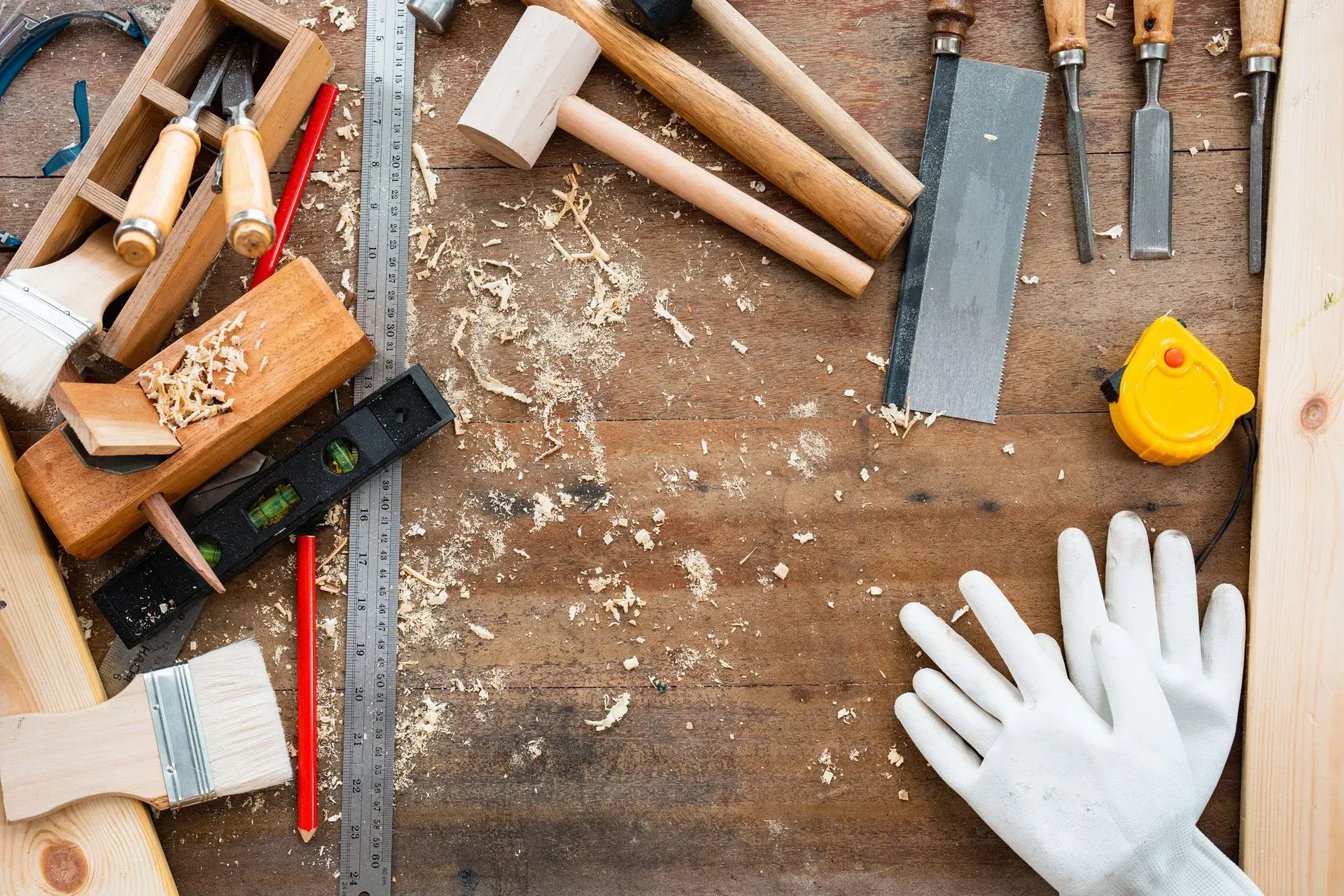 a person wearing white gloves is standing in front of a wooden table filled with tools
