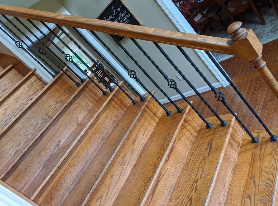 a wooden staircase with a black railing in a house