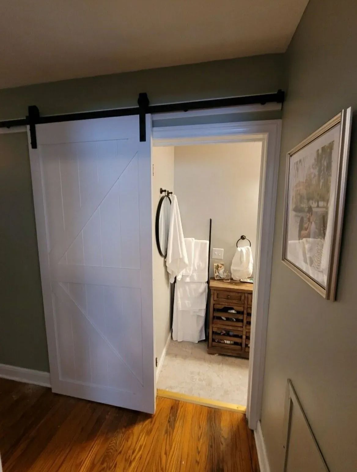 a bathroom with a sliding barn door leading to it