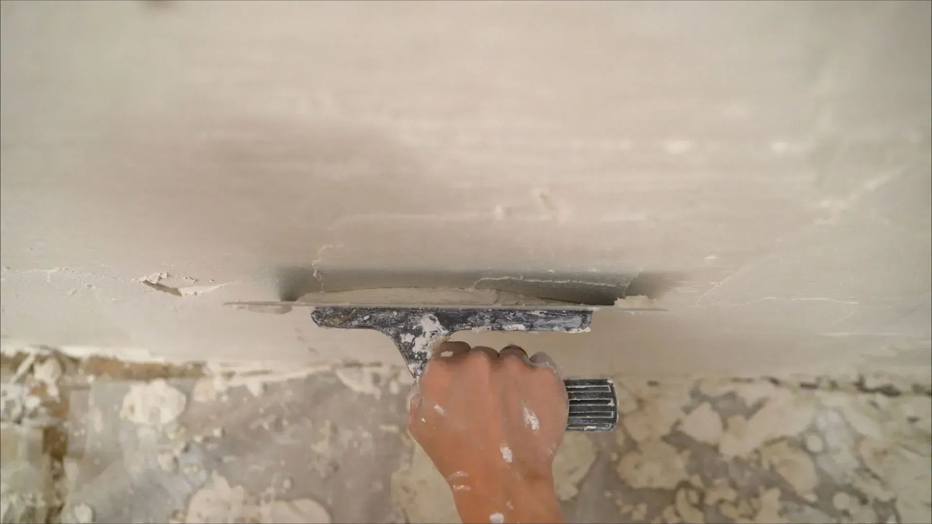 a person is plastering a wall with a trowel