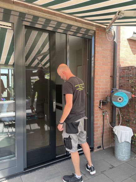 Wesselvastgoedonderhoud bezig met horren plaatsen en controleren