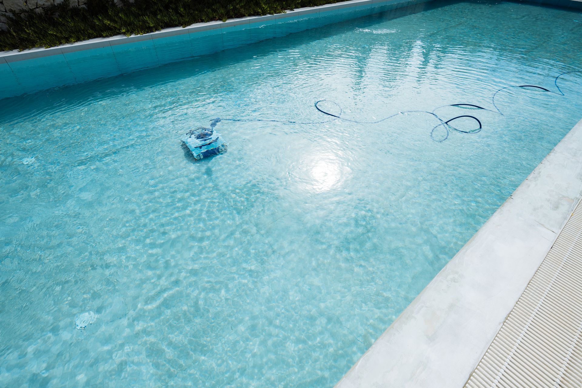 A pool vacuum cleaner in an empty swimming pool floor