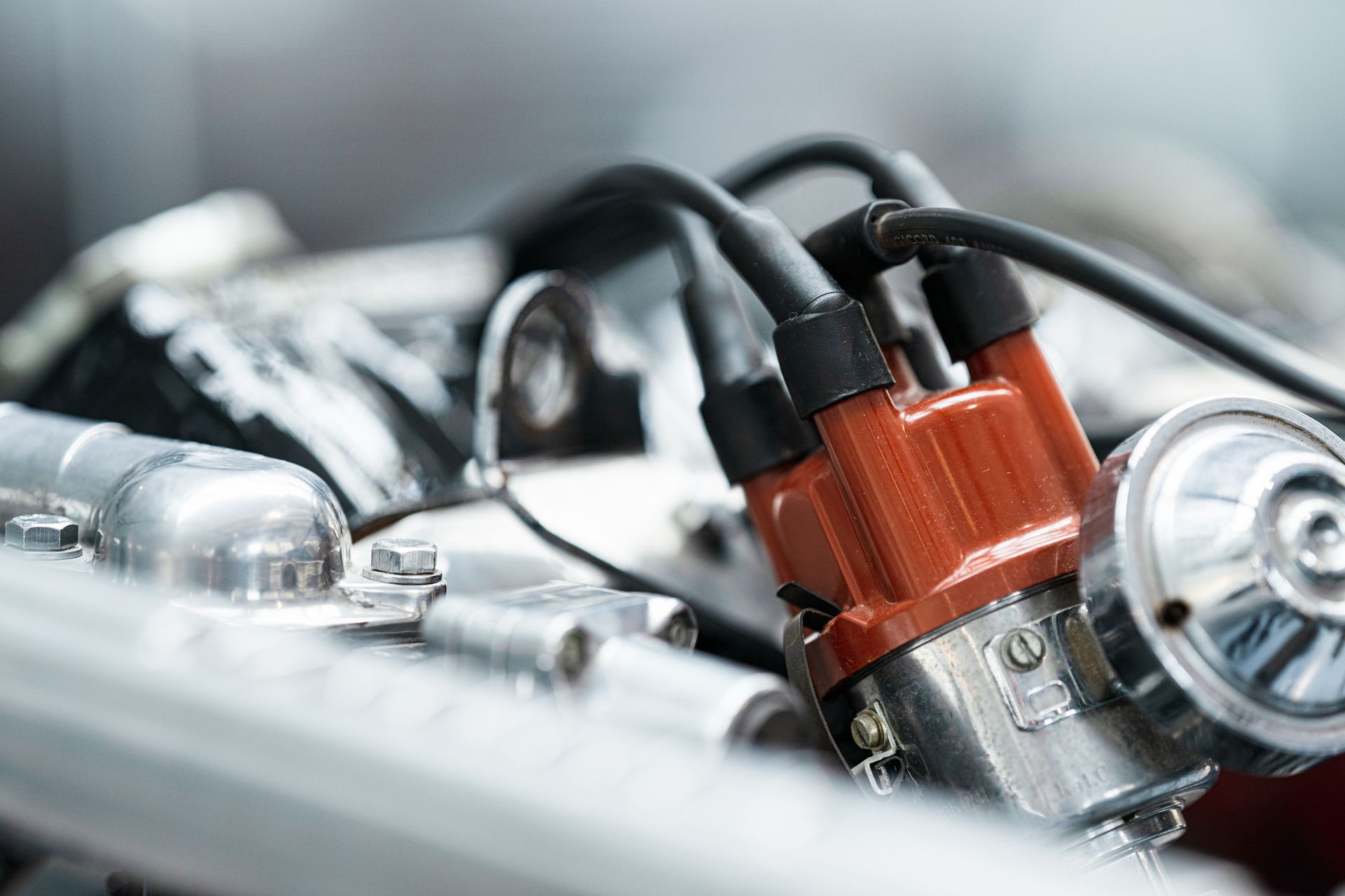 Close-up of a car engine with red ignition coils and black spark plug wires Close-up of a car engine with red ignition coils and black spark plug wires