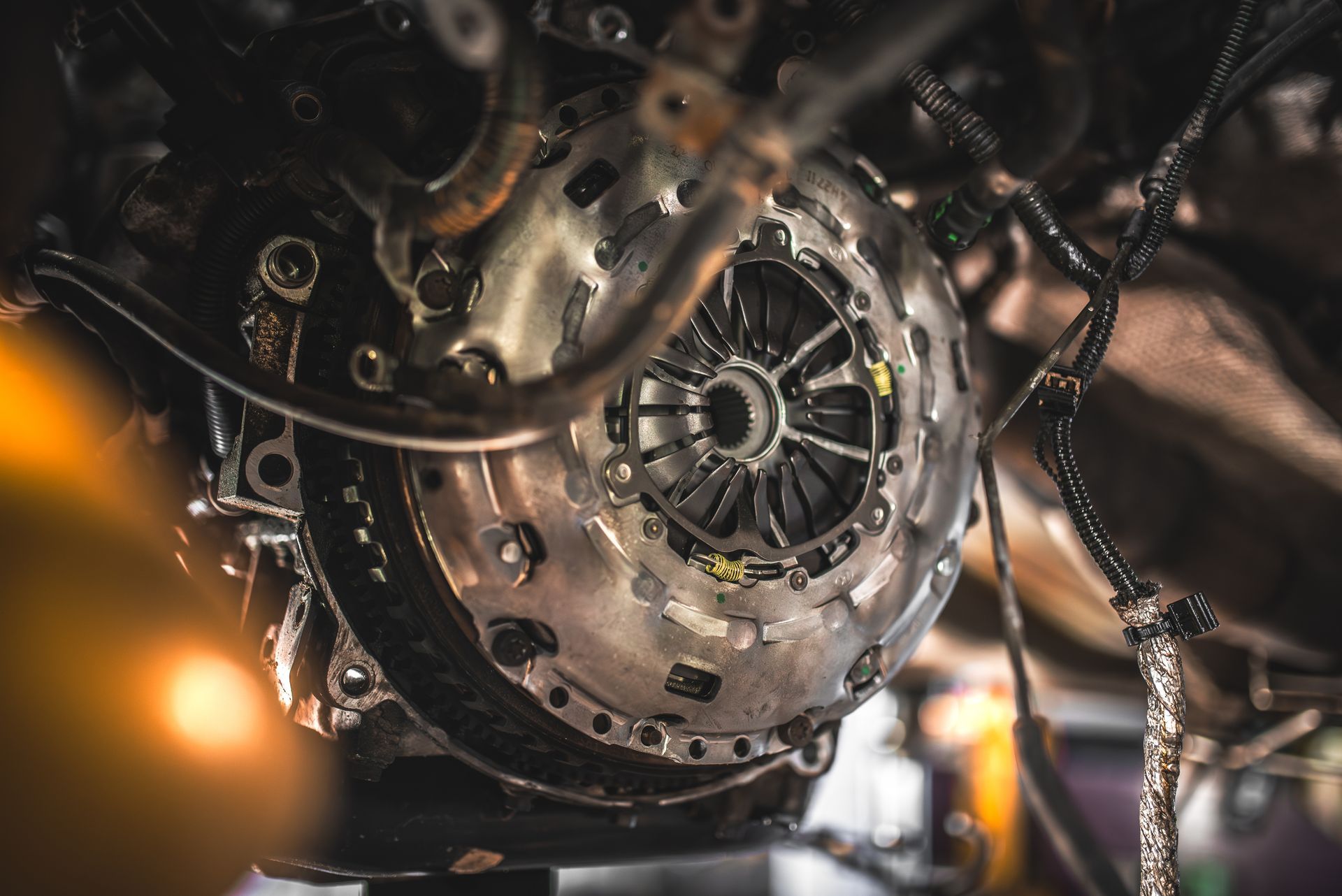 Close-up of a metal engine or gearbox with chains and bolts, lit by warm industrial light Close-up of a metal engine or gearbox with chains and bolts, lit by warm industrial light