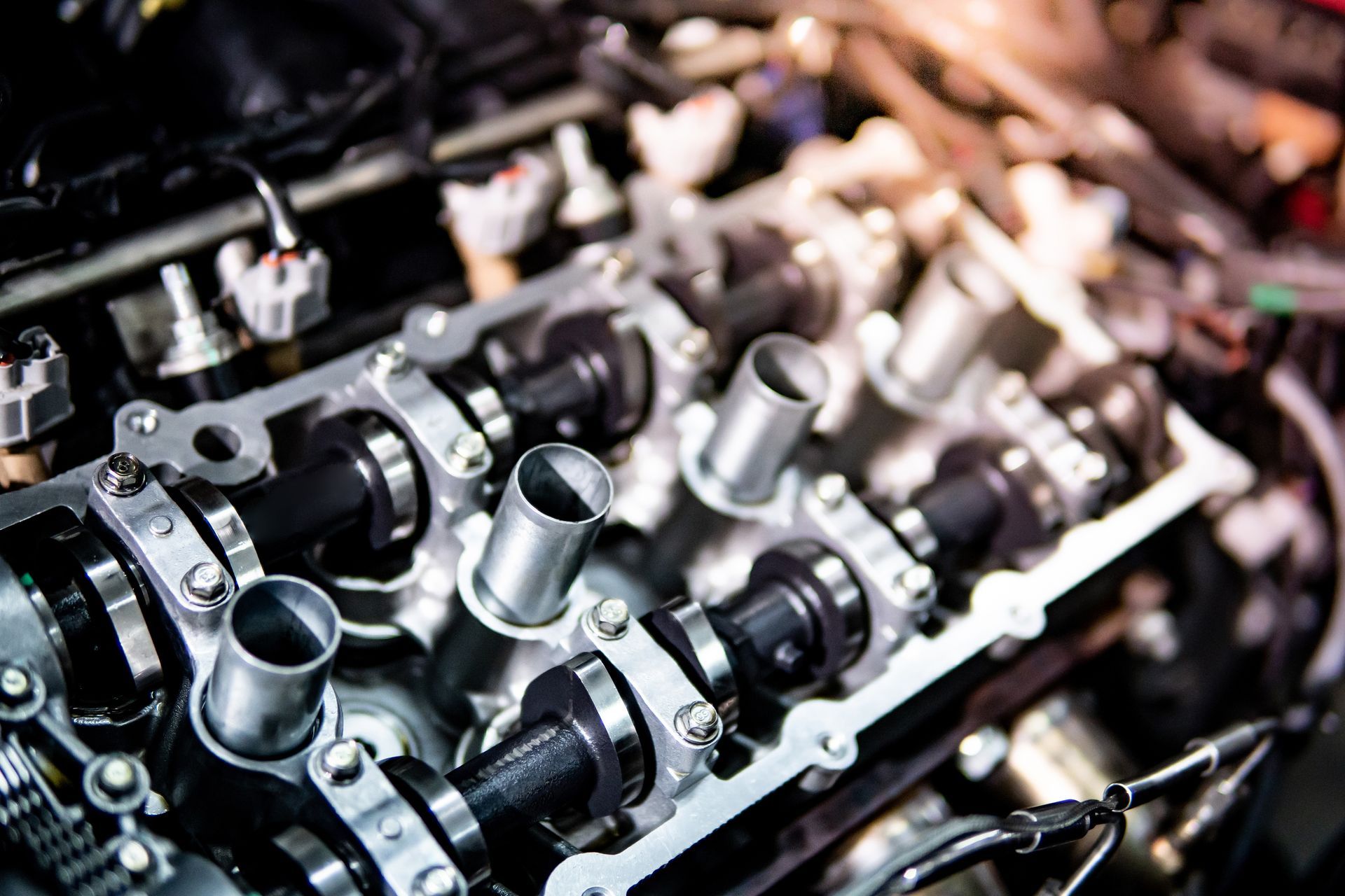 Close-up of shiny metal engine parts with bolts and hoses in a workshop setting Close-up of shiny metal engine parts with bolts and hoses in a workshop setting