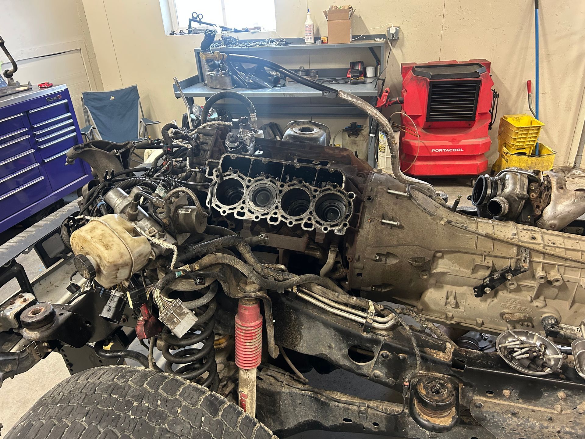 Mechanic wearing white gloves working under a car’s open hood in a repair shop Mechanic wearing white gloves working under a car’s open hood in a repair shop