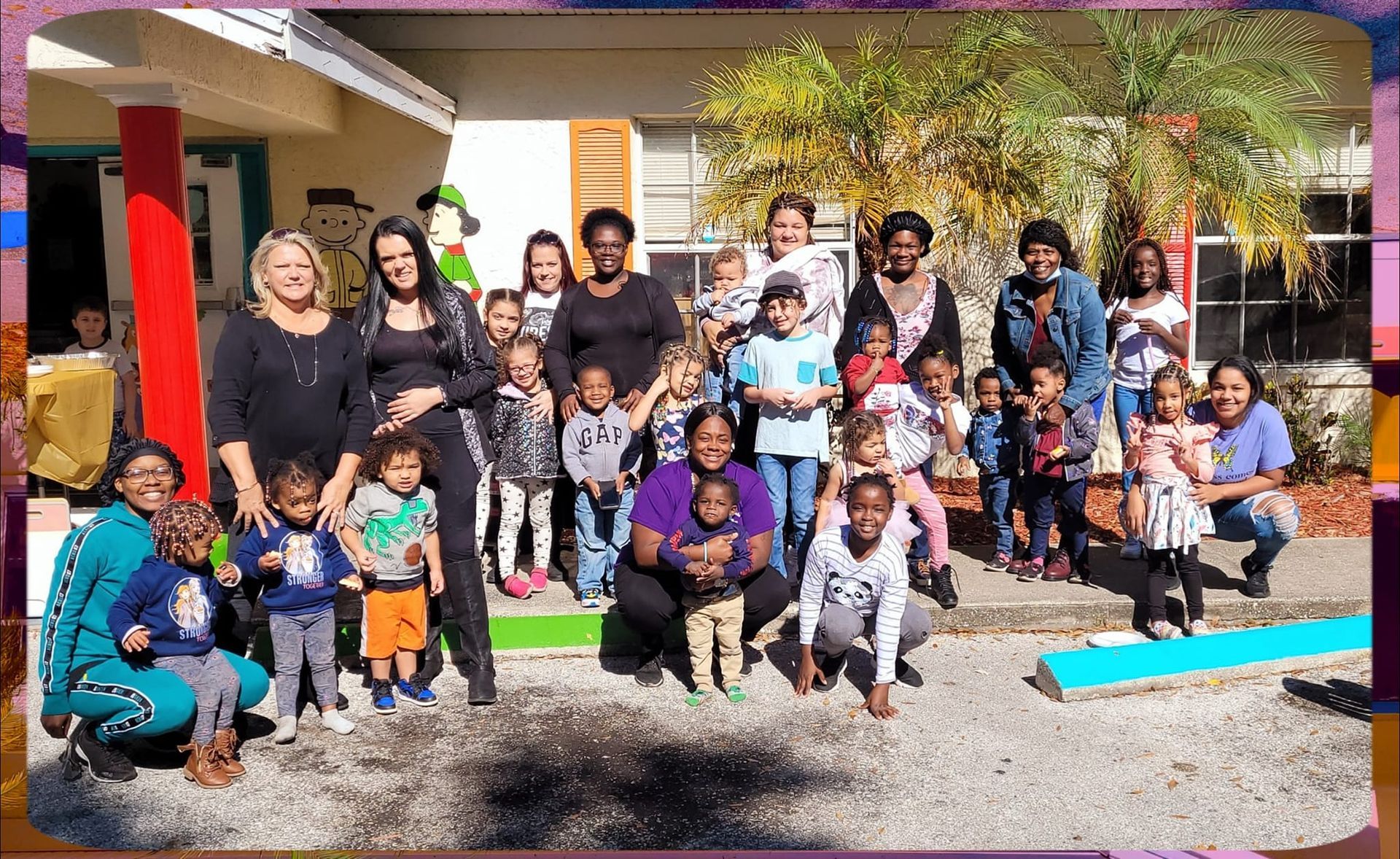 A group of people are posing for a picture in front of a building.