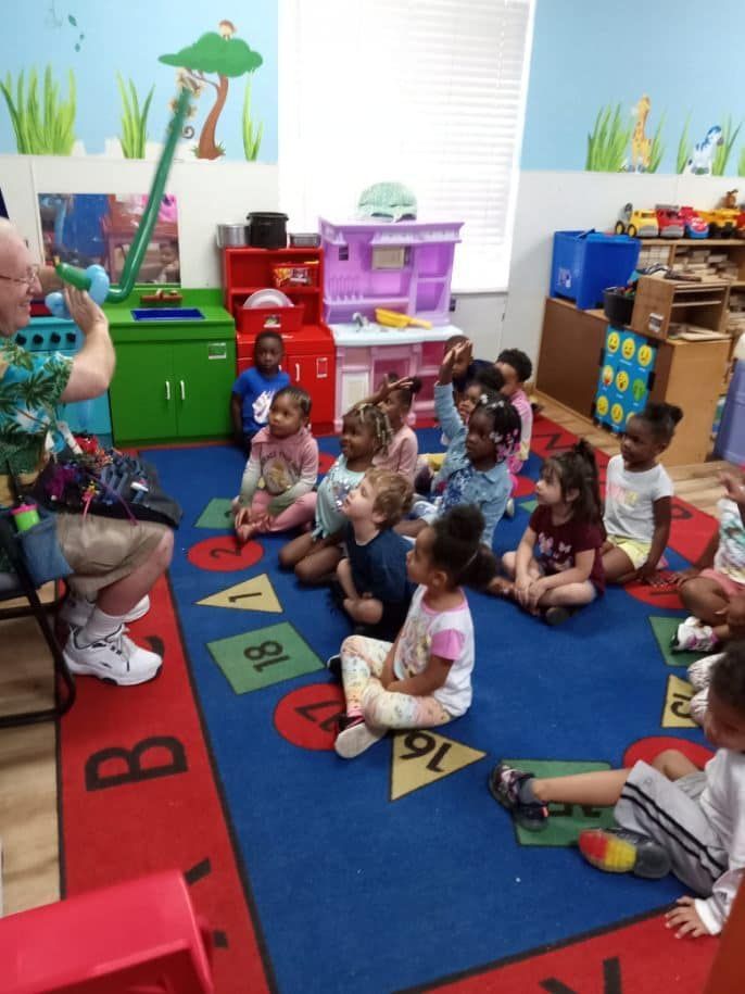 A group of children are sitting on the floor in a classroom