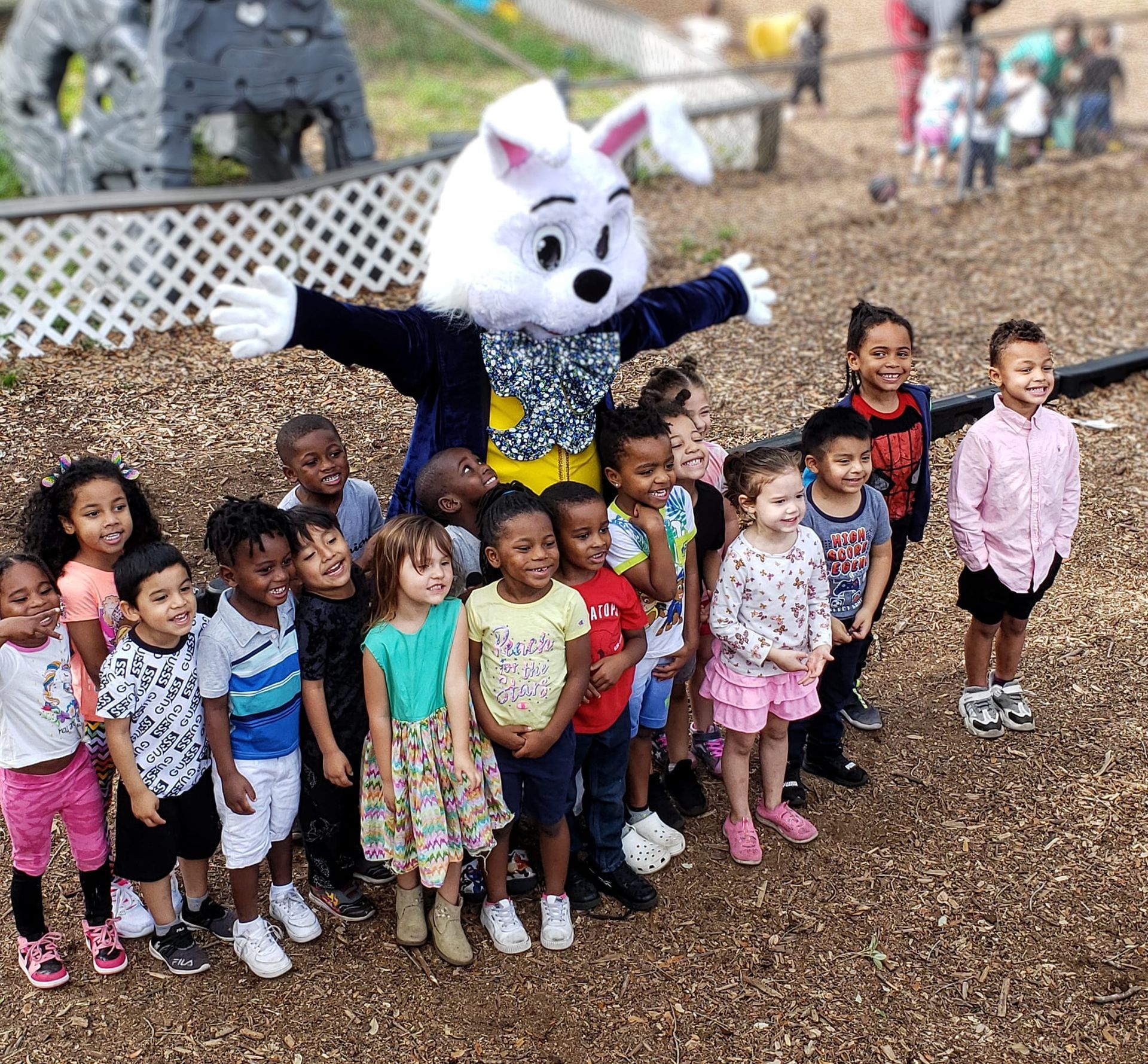 A group of children are posing for a picture with a bunny mascot.