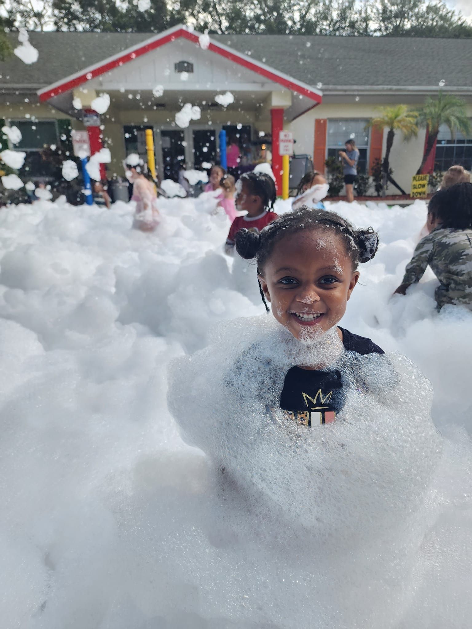 A little girl is standing in a pile of foam