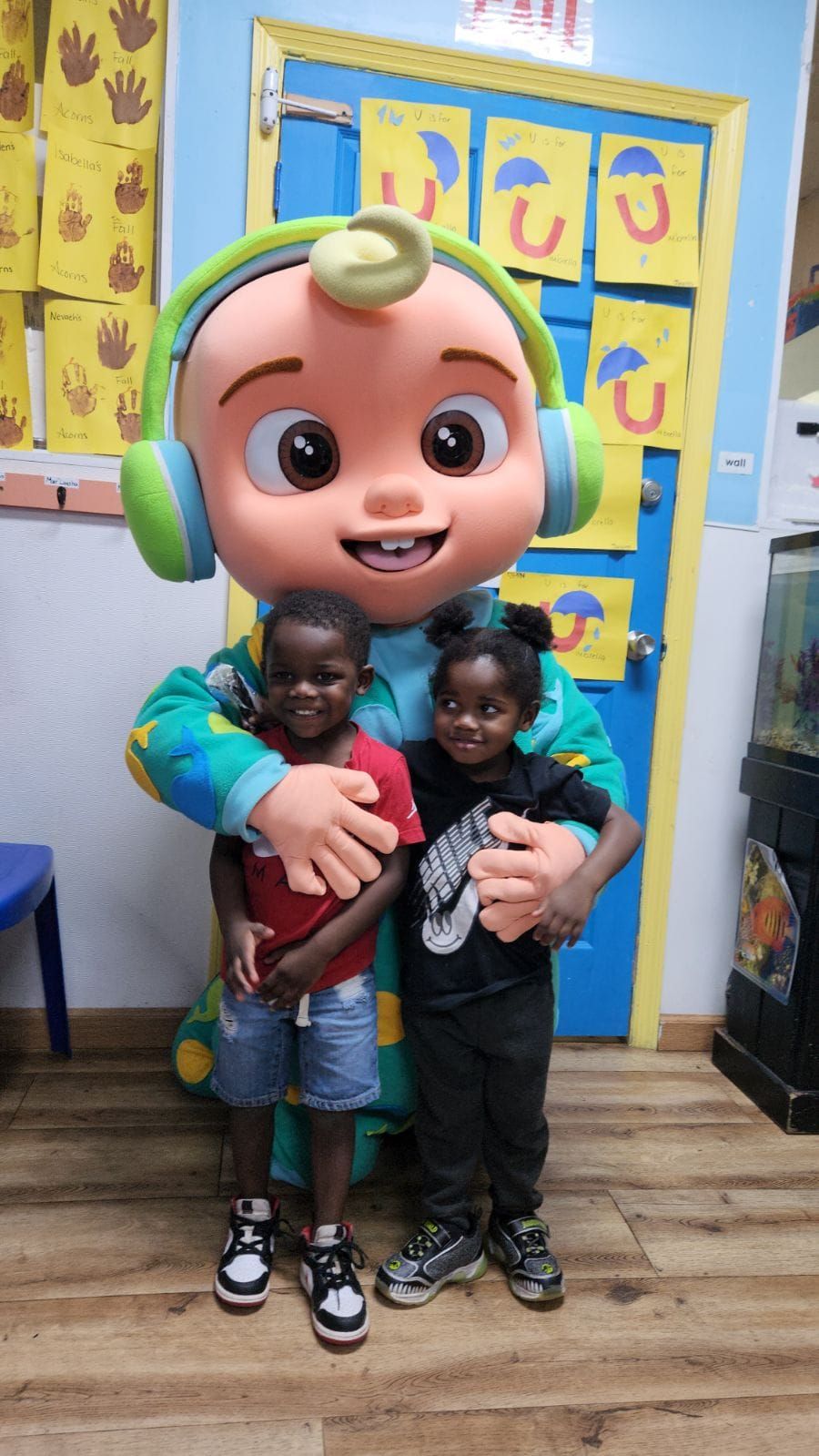 A cartoon character is posing for a picture with two children.