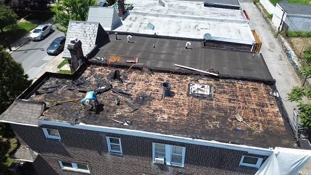 An aerial view of a building with a roof that is being repaired.