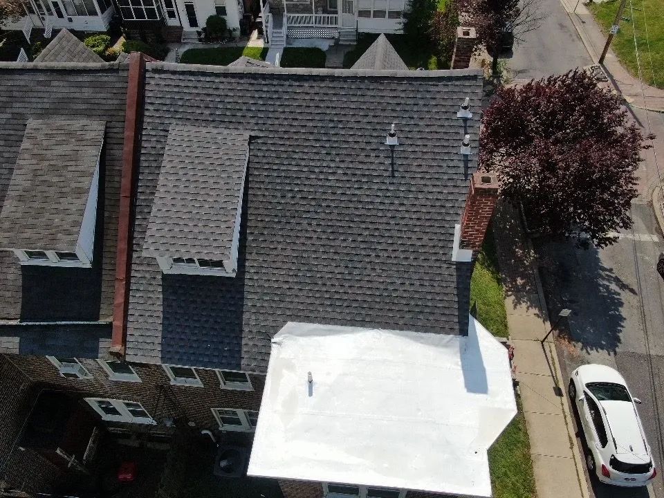 An aerial view of a house with a white roof.