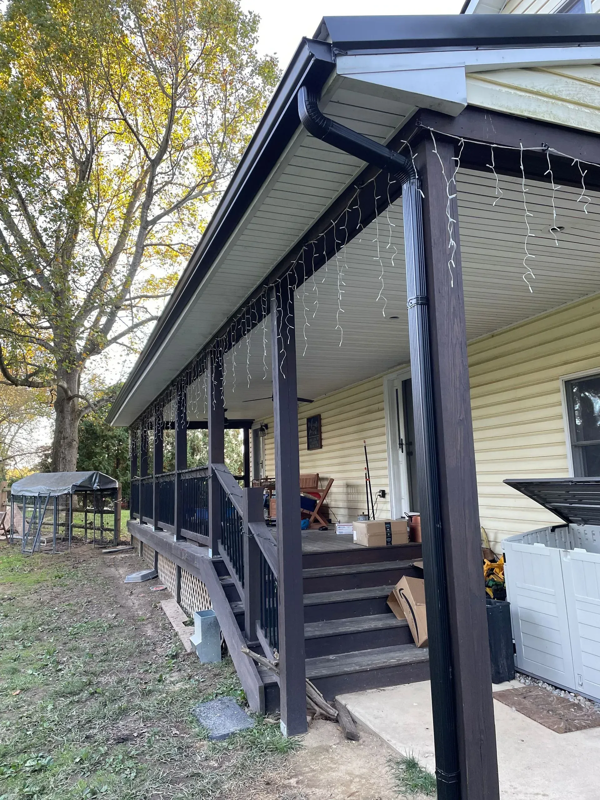 A porch with stairs leading up to it and christmas lights on it.