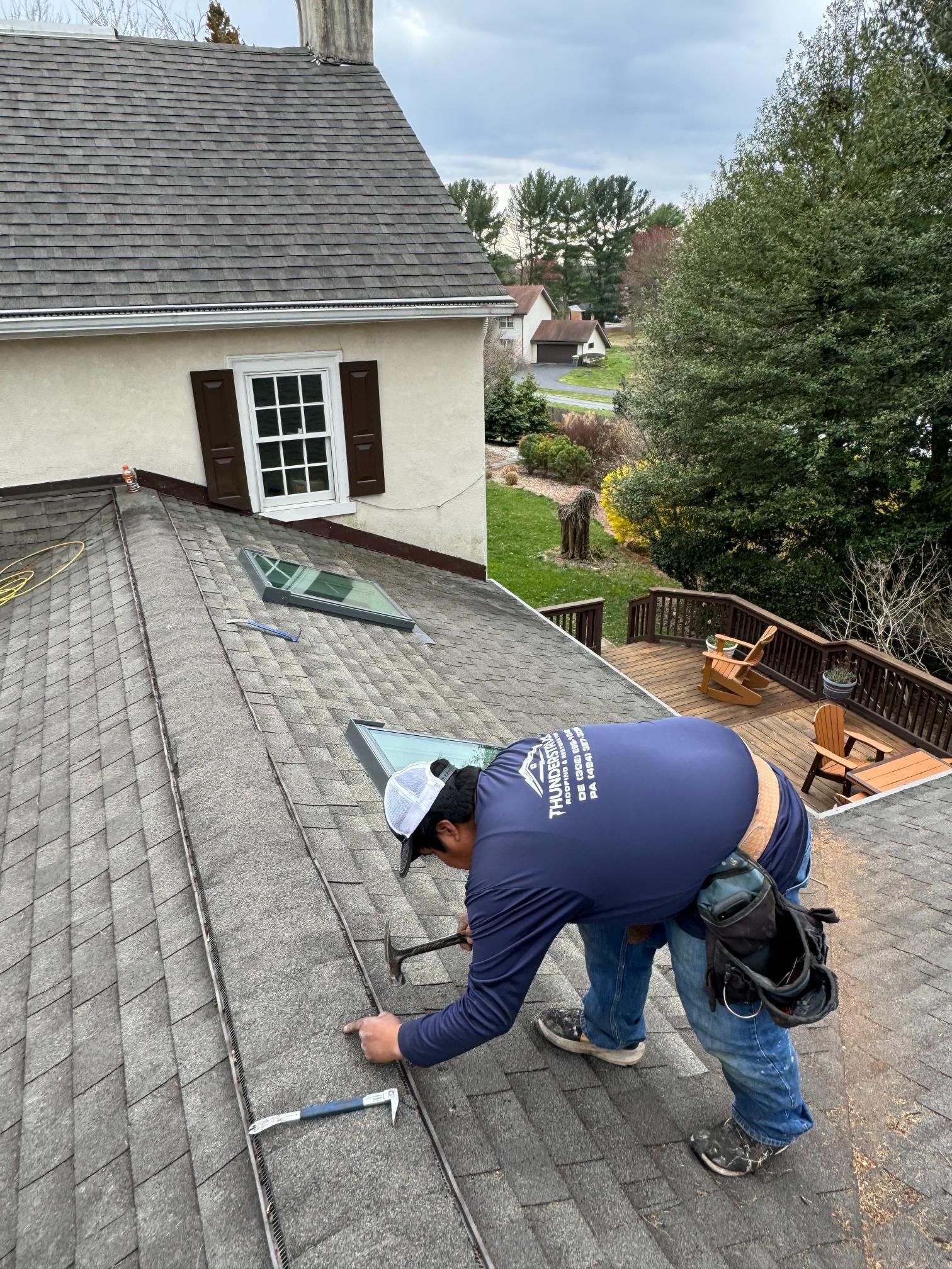 A man is working on the roof of a house.
