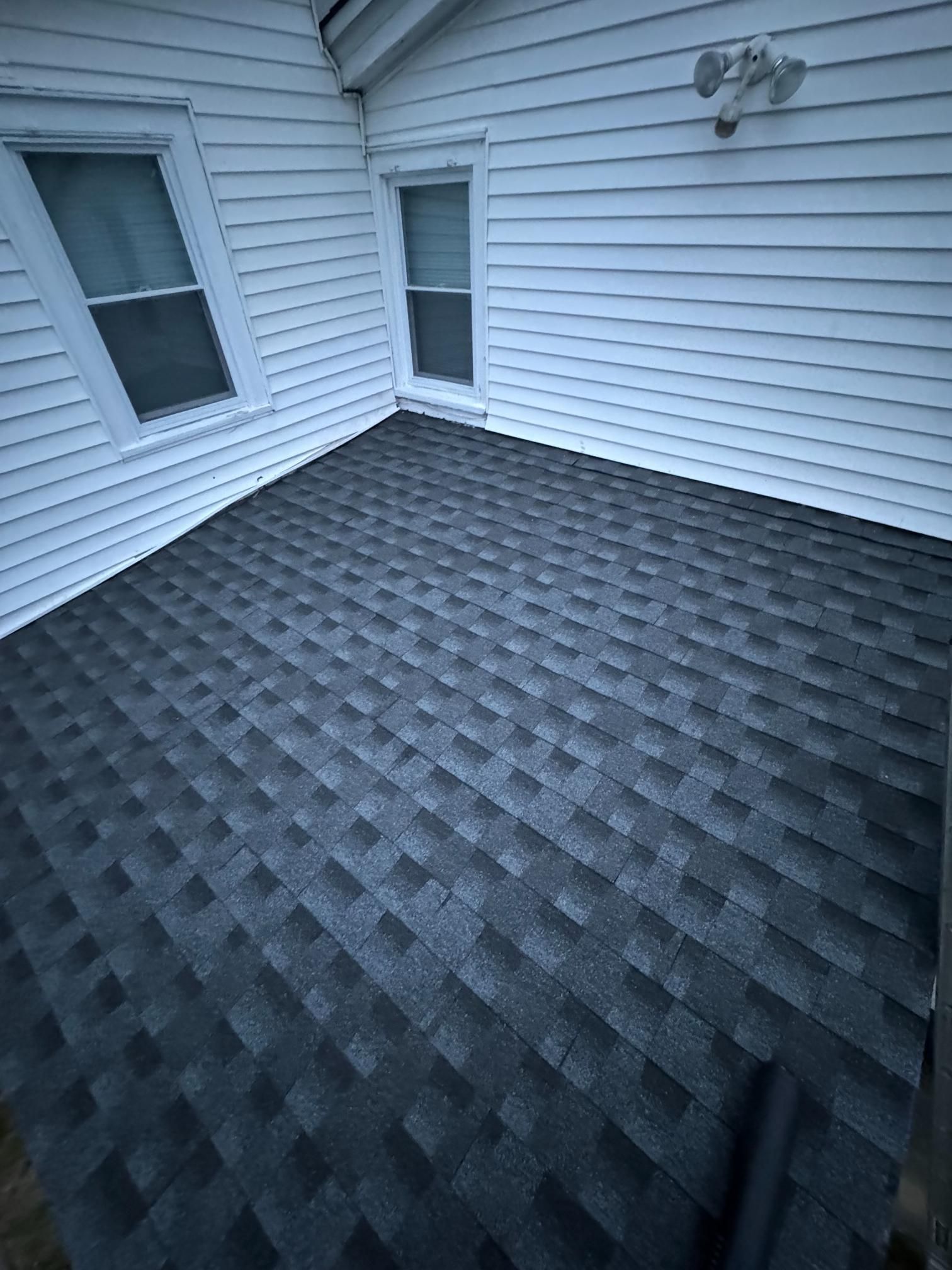 A black roof is sitting on top of a white house.