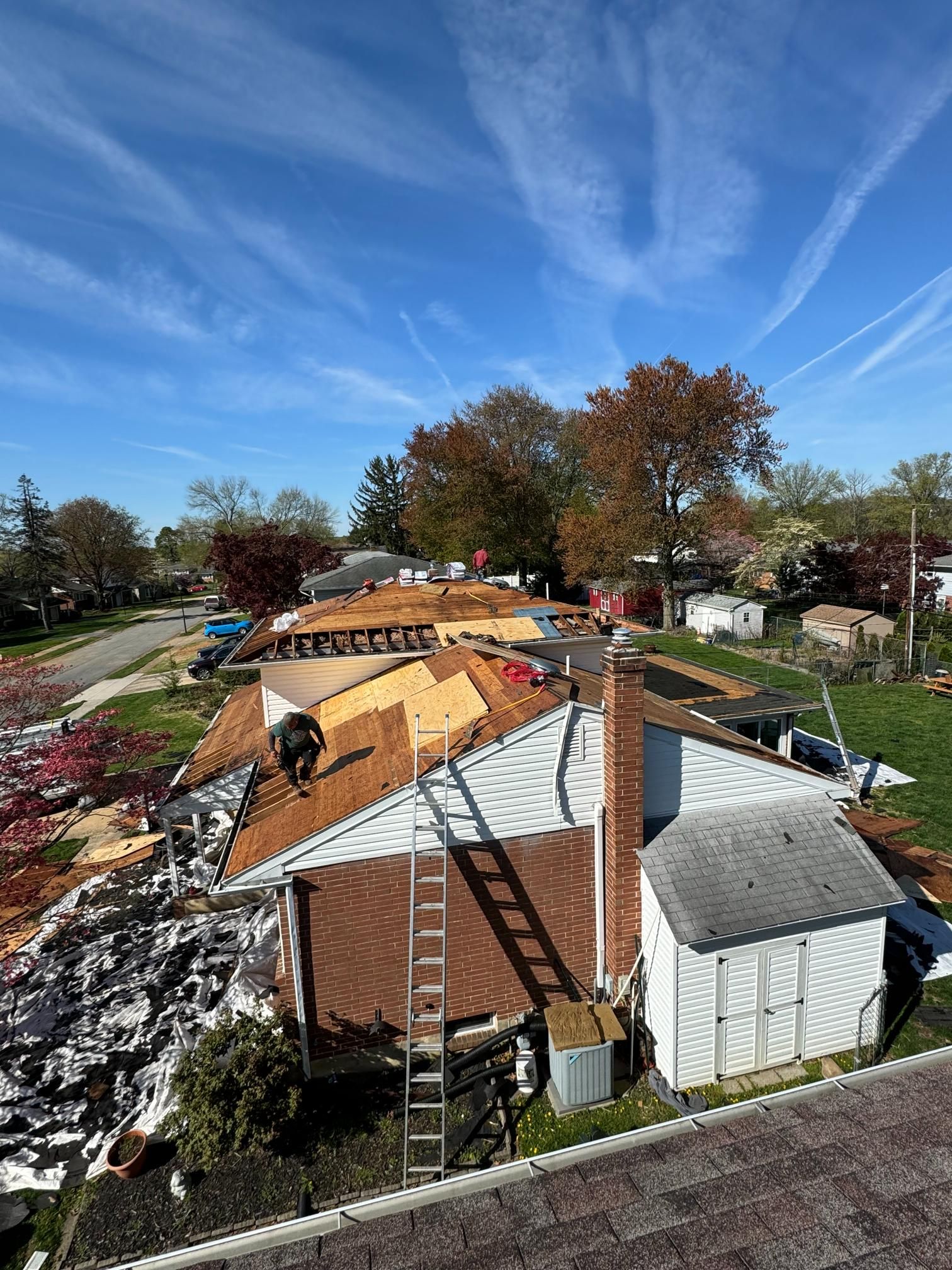 An aerial view of a house being remodeled with a roof being installed.