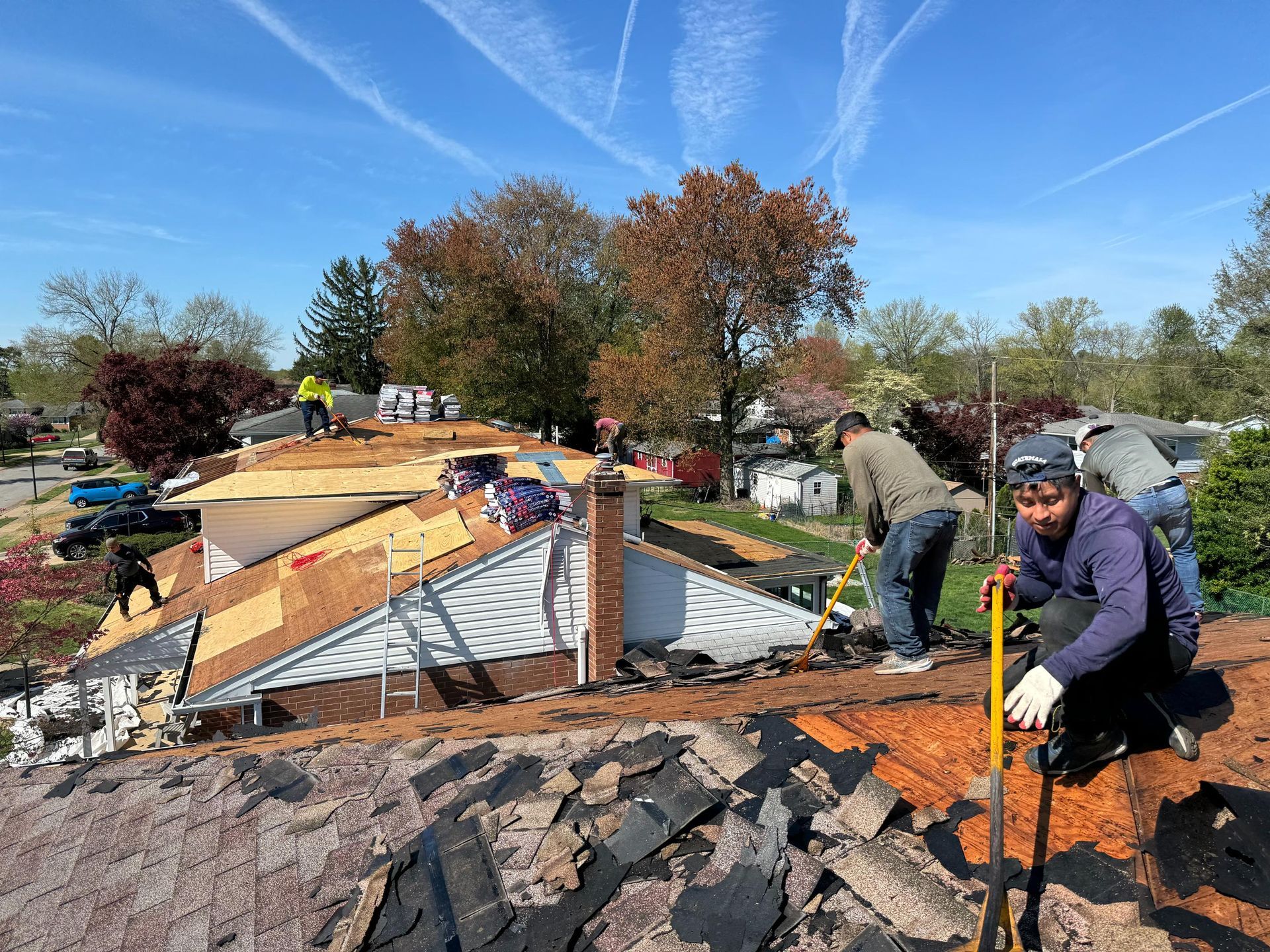 A group of men are working on the roof of a house.