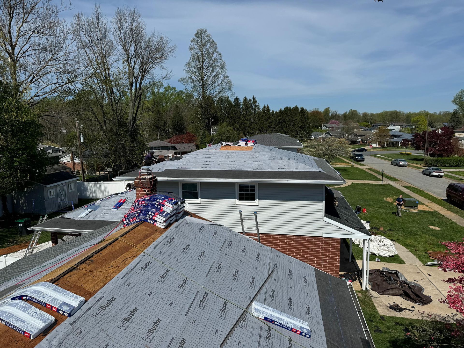 A roof is being installed on a house in a residential area.