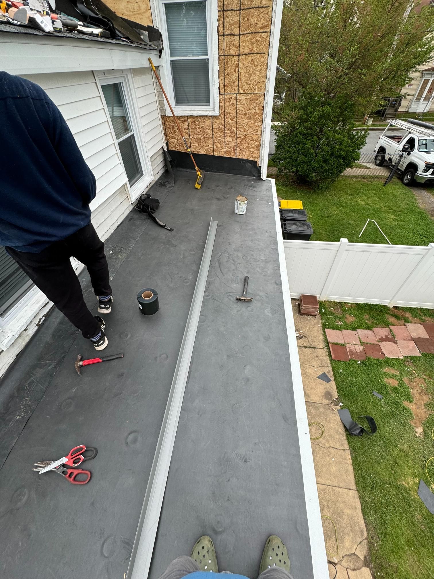 A man is standing on the roof of a house.