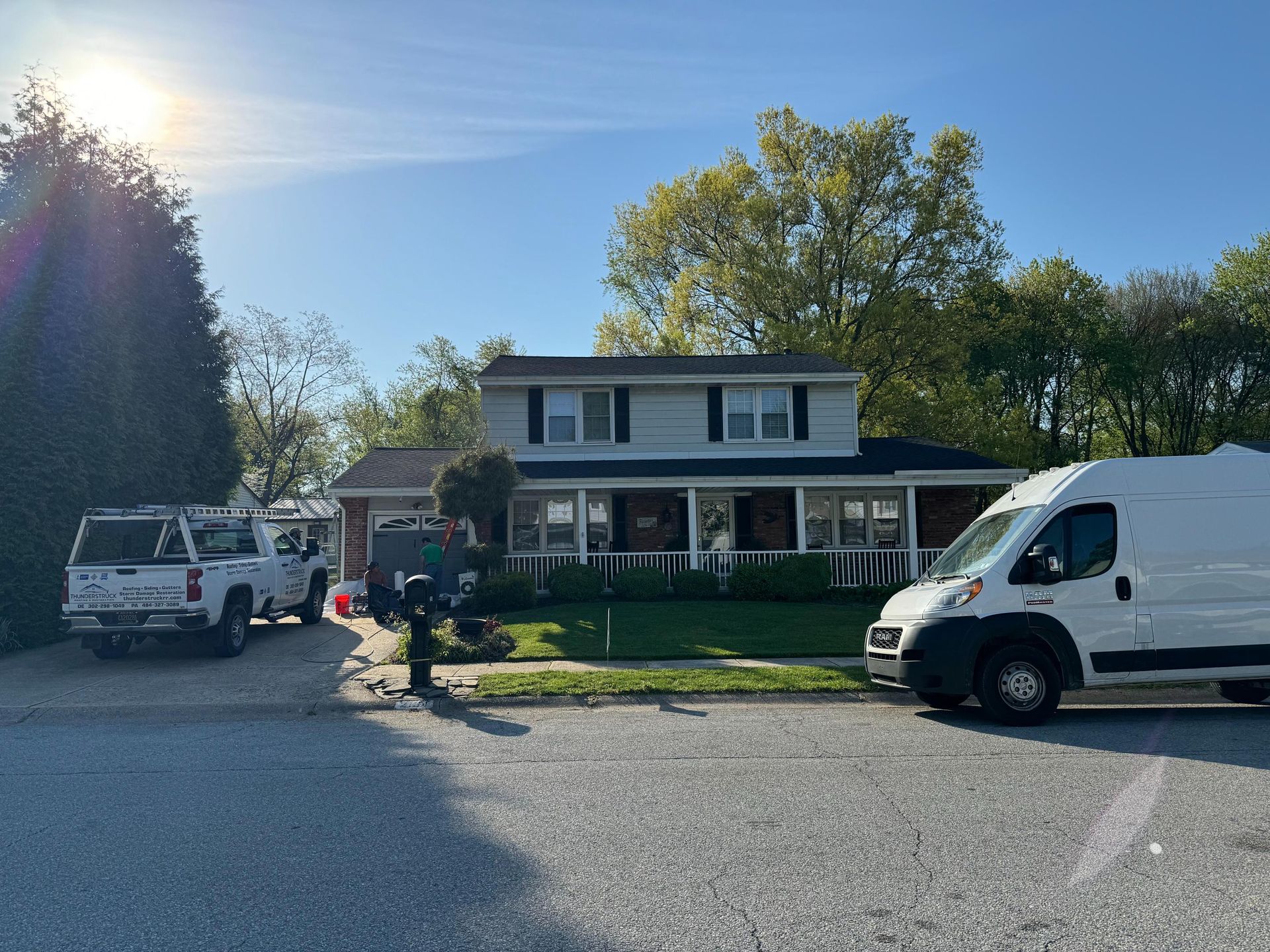 A white van is parked in front of a house.