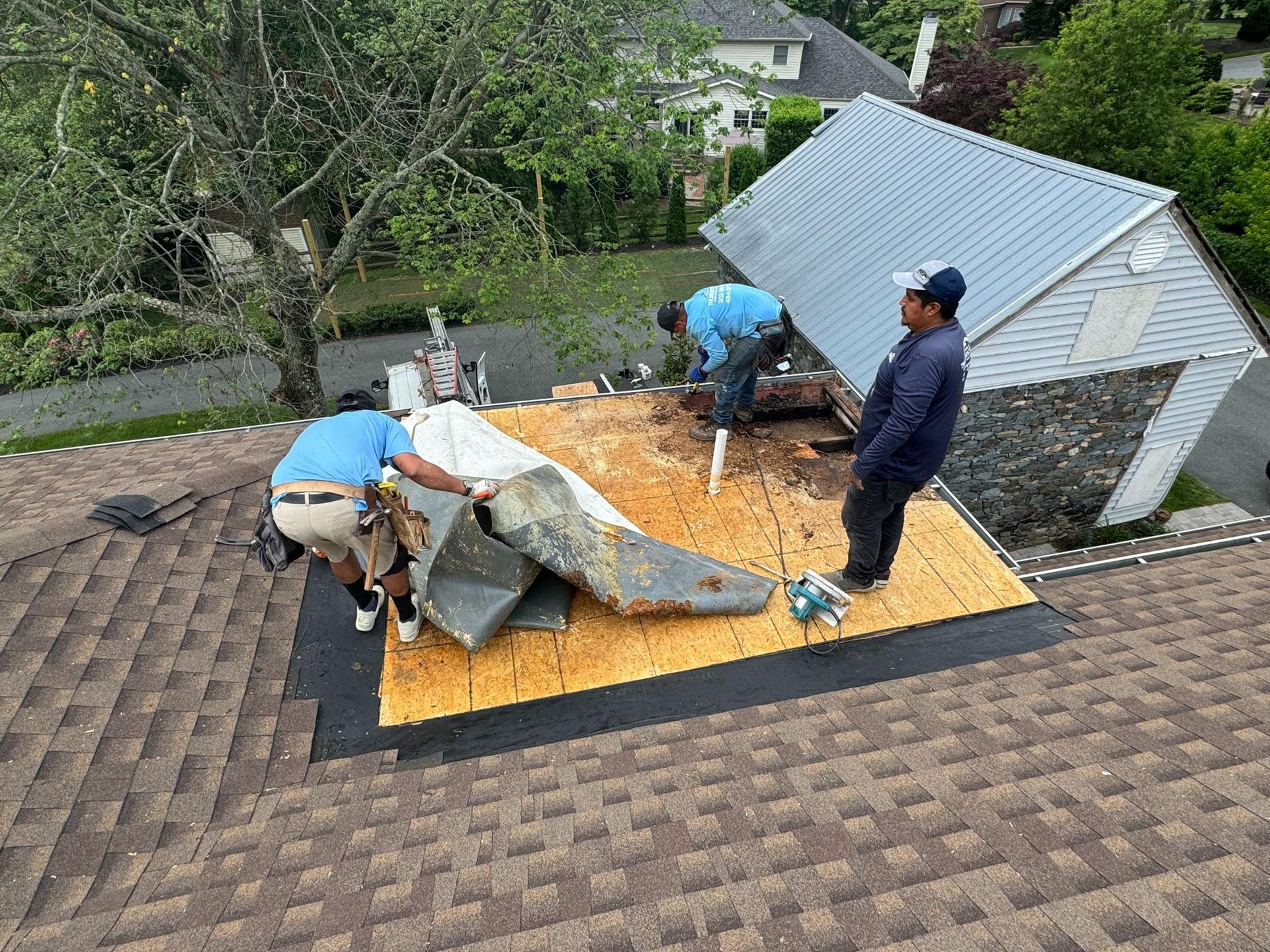 A group of men are working on the roof of a house.