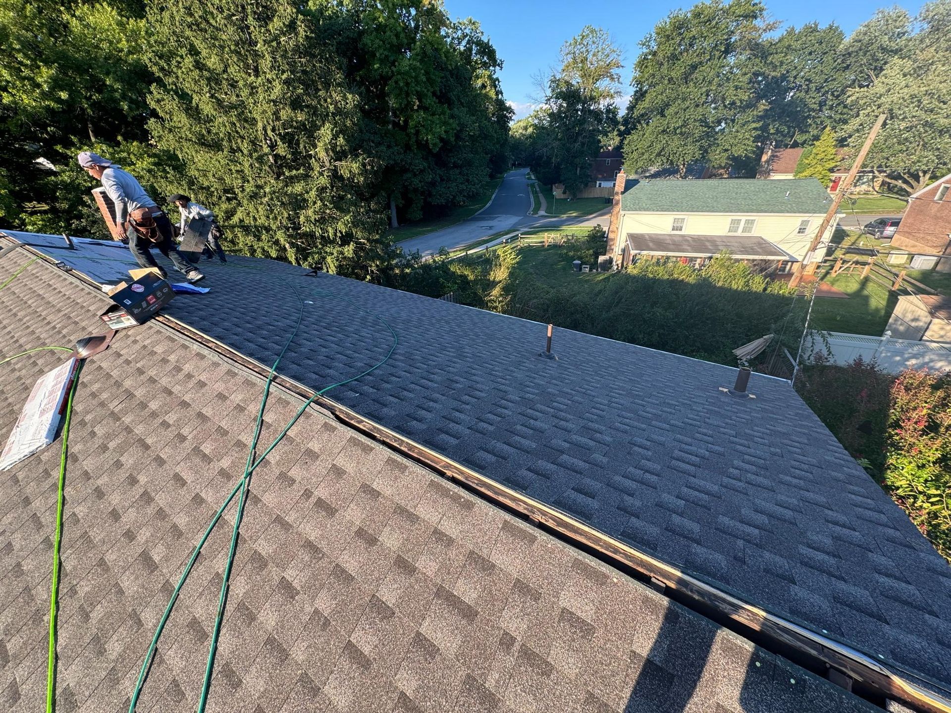 A group of people are working on the roof of a house.