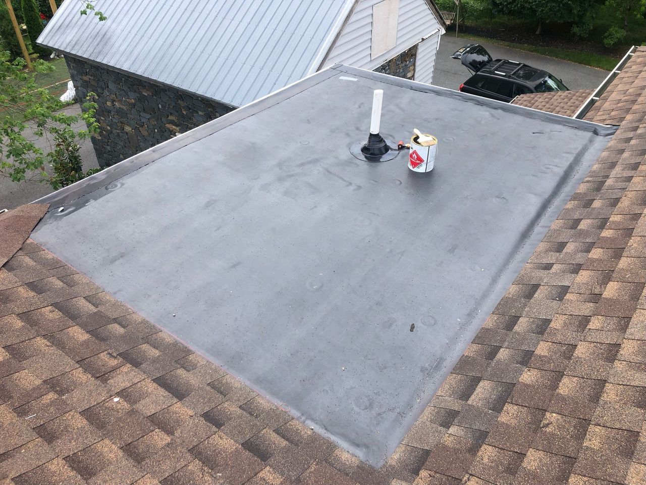 A roof with a rubber roof and a chimney on it.