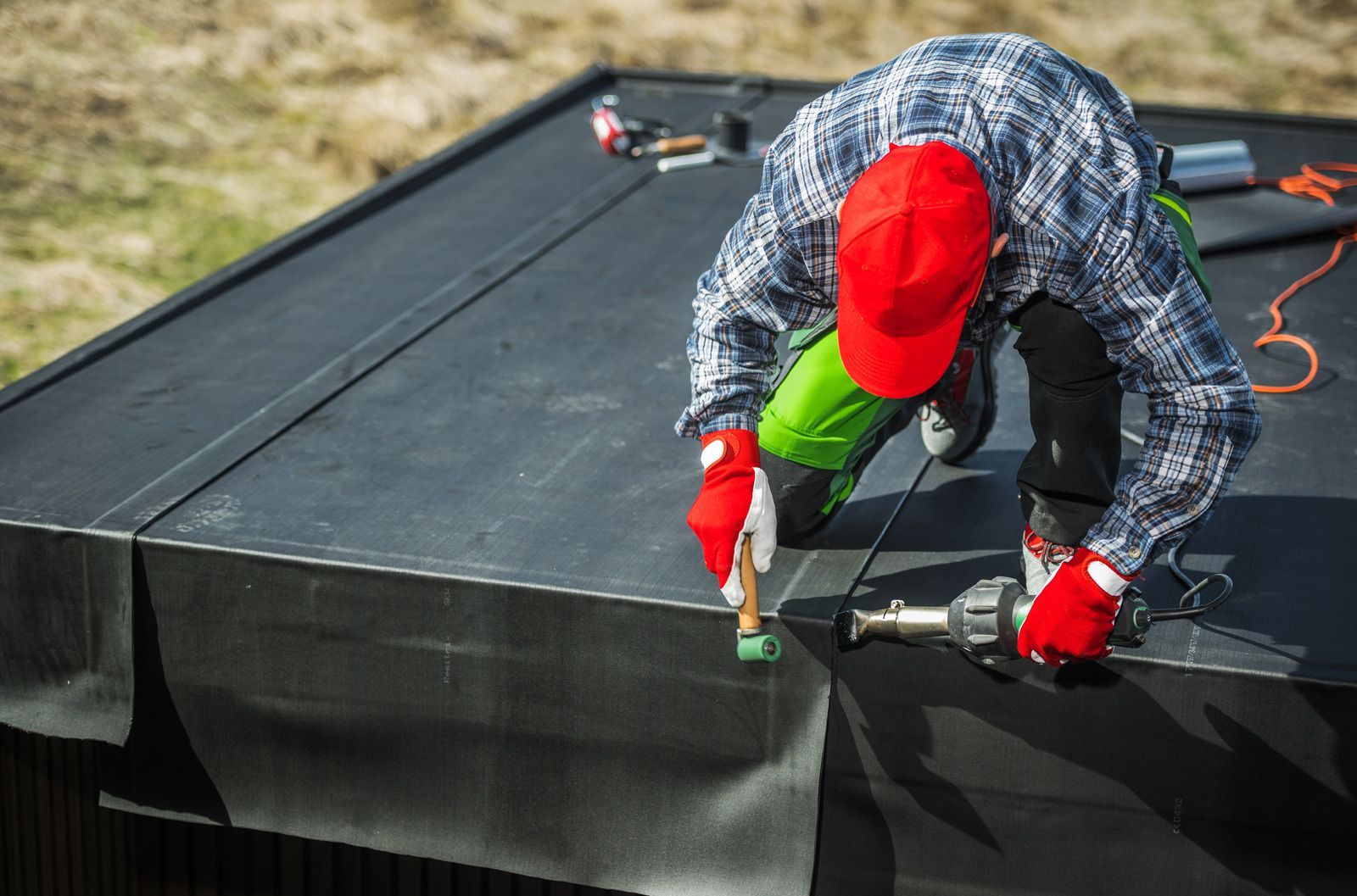 A man is working on a roof with a hammer.