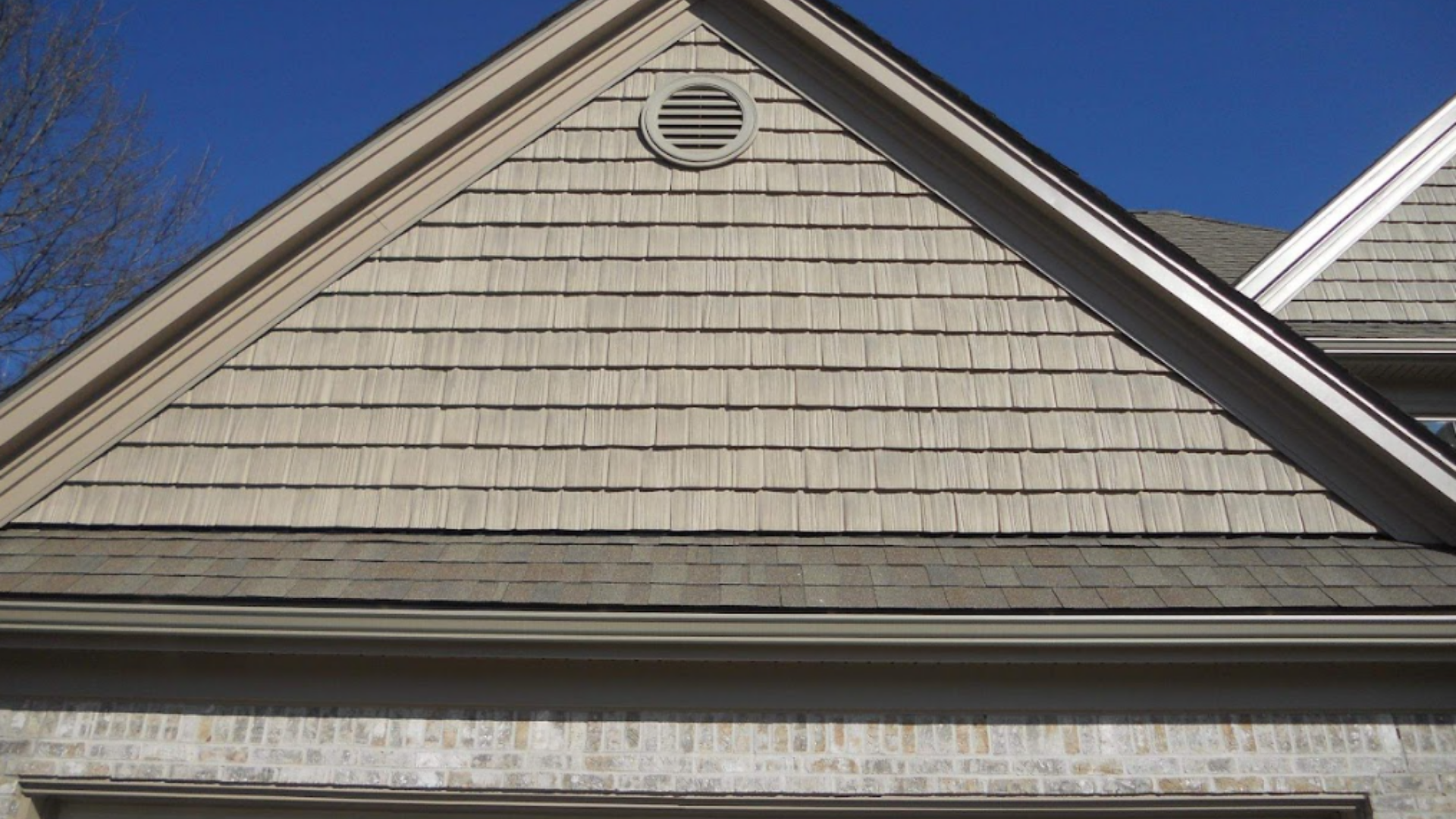 Wooden deck frame under construction near a house with windows.