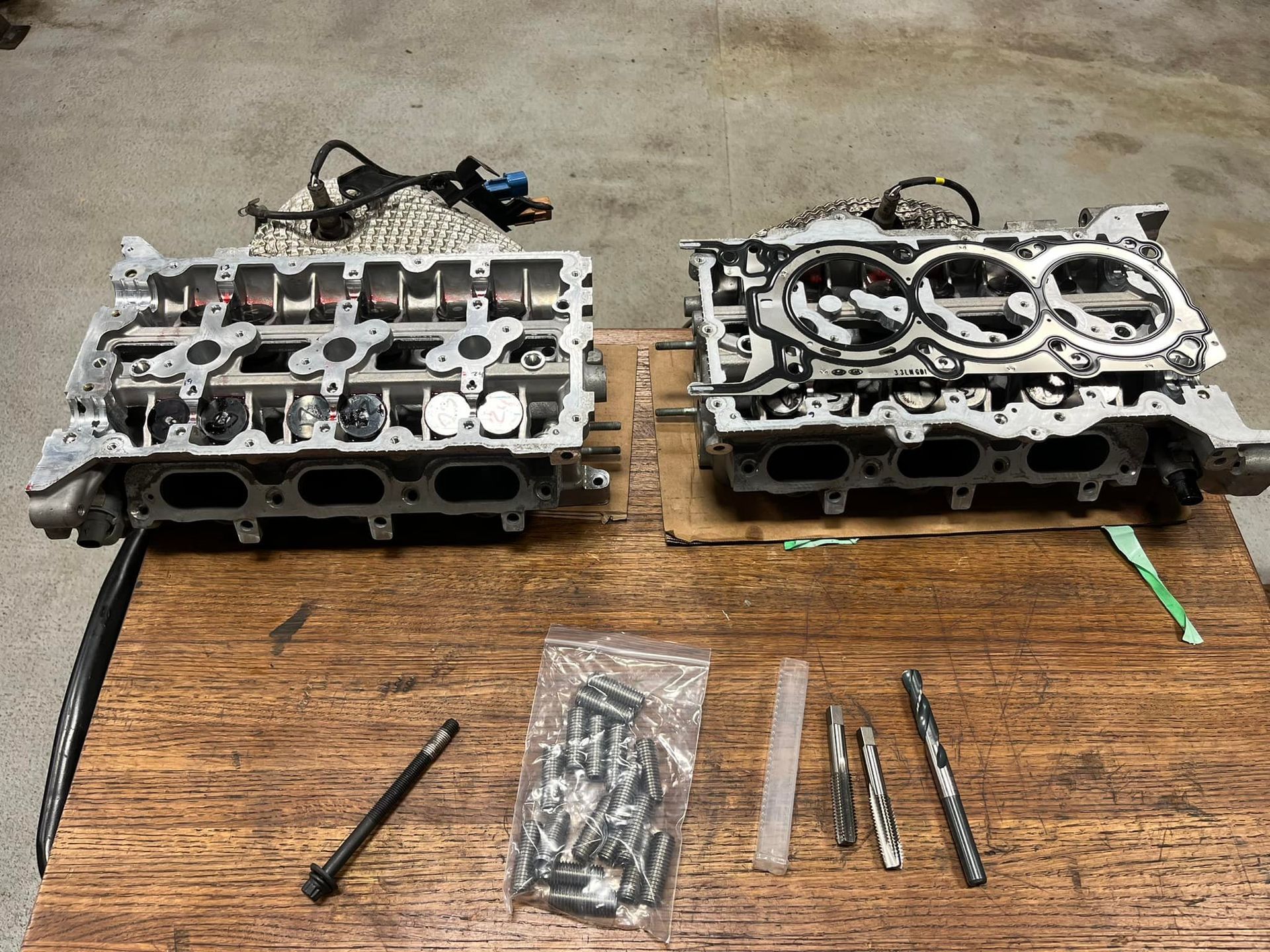 Two Engine Heads Are Sitting on a Wooden Table | Golden Valley Automotive