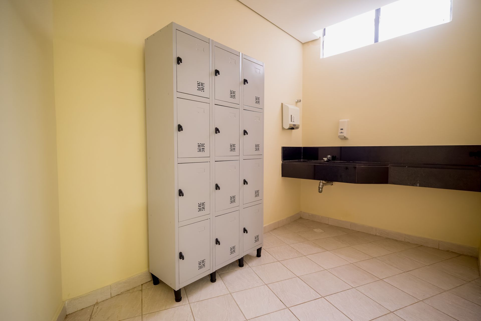 Armários e pia em um vestiário amarelo vibrante.