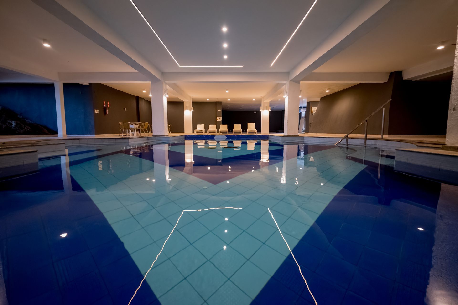 Uma grande piscina coberta com piso de ladrilho azul