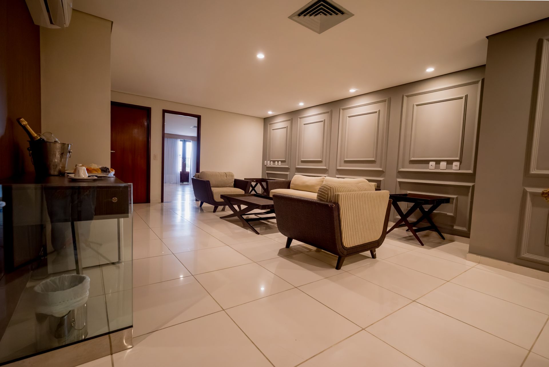 Uma sala de estar com um sofá, cadeiras e uma mesa.